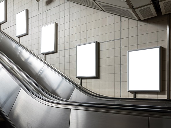 Ad billboards going up an escalator in an underground station